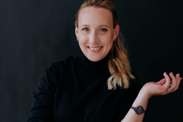 Photo of Anna Klevtcova in a black jumper and jeans against a dark background